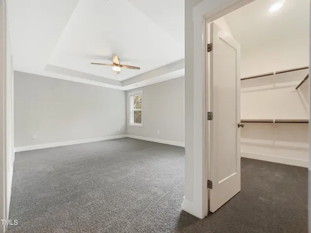 an empty room with a ceiling fan and window