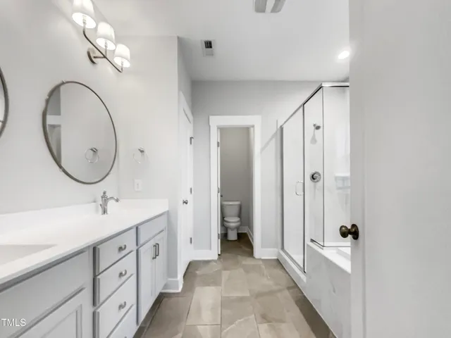 a spacious bathroom with a double vanity sink and a mirror