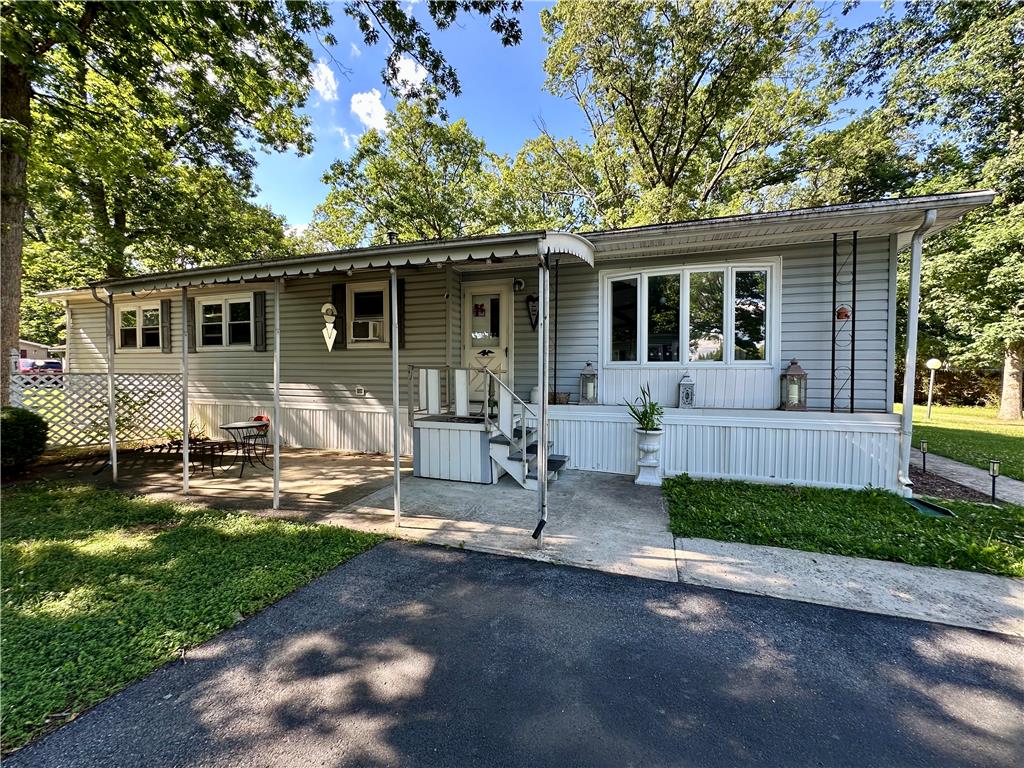 381 Red Oak Lane Bath, PA 18014 - Photo 1 of 27 A welcoming front porch extends across this charming manufactured home, nestled amidst mature trees.