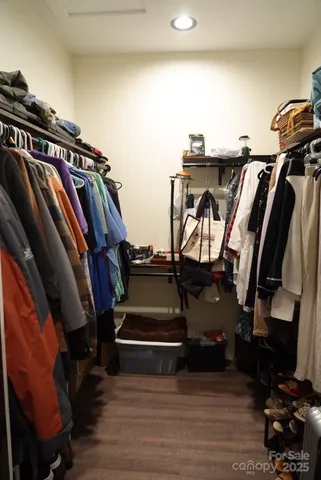 a view of walk in closet with clothes and shoes