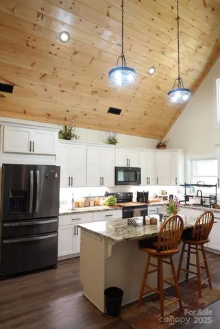 a kitchen with kitchen island a white counter top space cabinets and stainless steel appliances