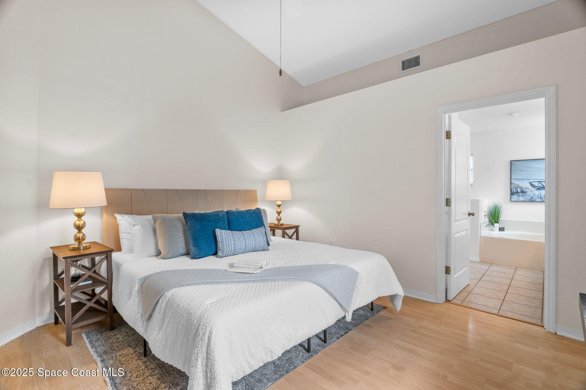 4664 Grand Meadows Boulevard Melbourne, FL 32934 - Photo 14 of 32 a bedroom with a bed and a lamp on table