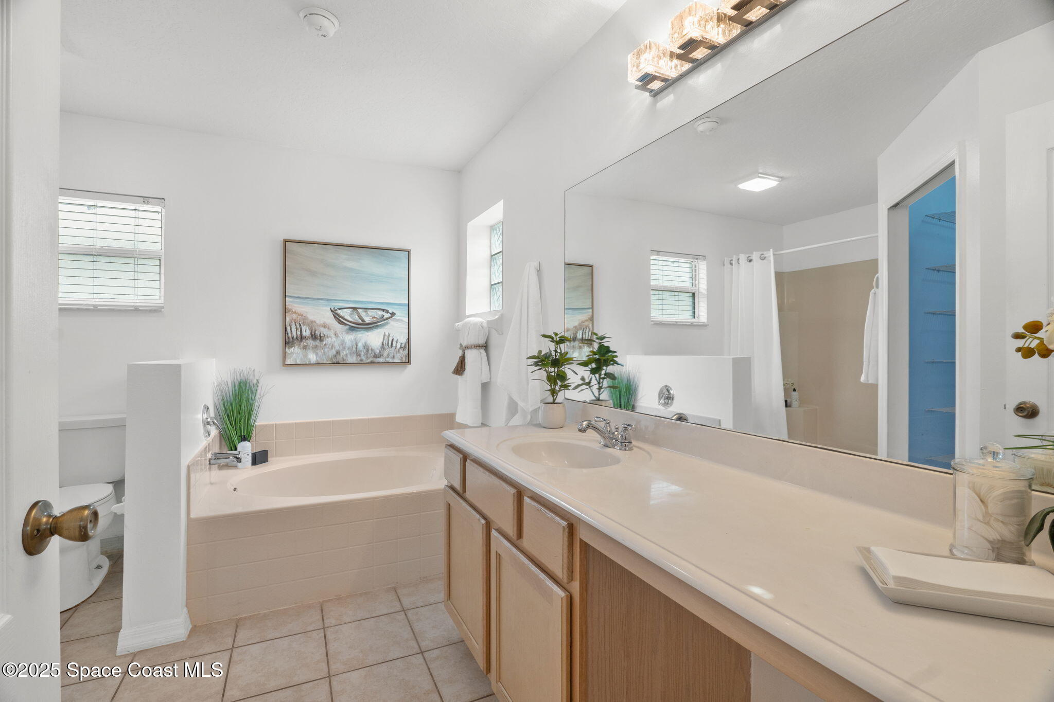 4664 Grand Meadows Boulevard Melbourne, FL 32934 - Photo 15 of 32 a spacious bathroom with a bathtub shower and a sink