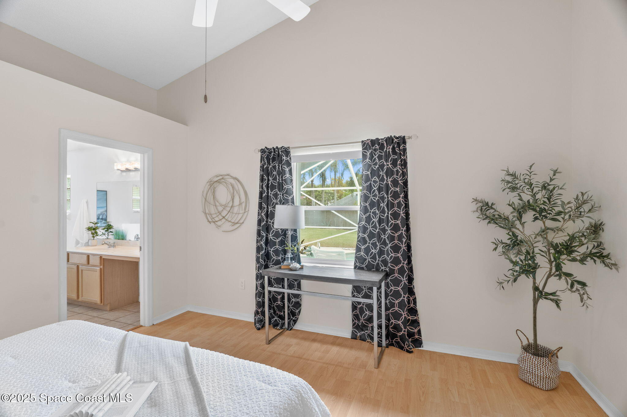 4664 Grand Meadows Boulevard Melbourne, FL 32934 - Photo 19 of 32 a bedroom with a bed and a potted plant