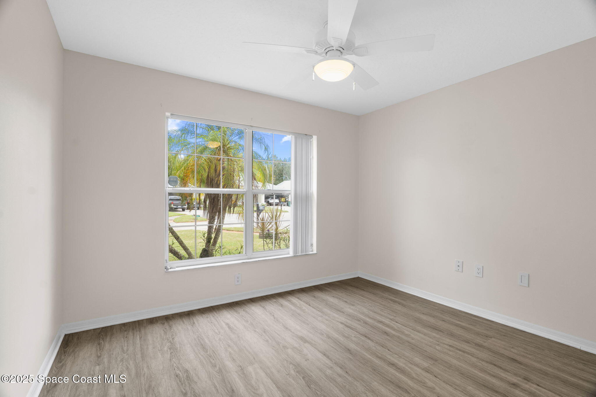 4664 Grand Meadows Boulevard Melbourne, FL 32934 - Photo 4 of 32 an empty room with wooden floor and windows