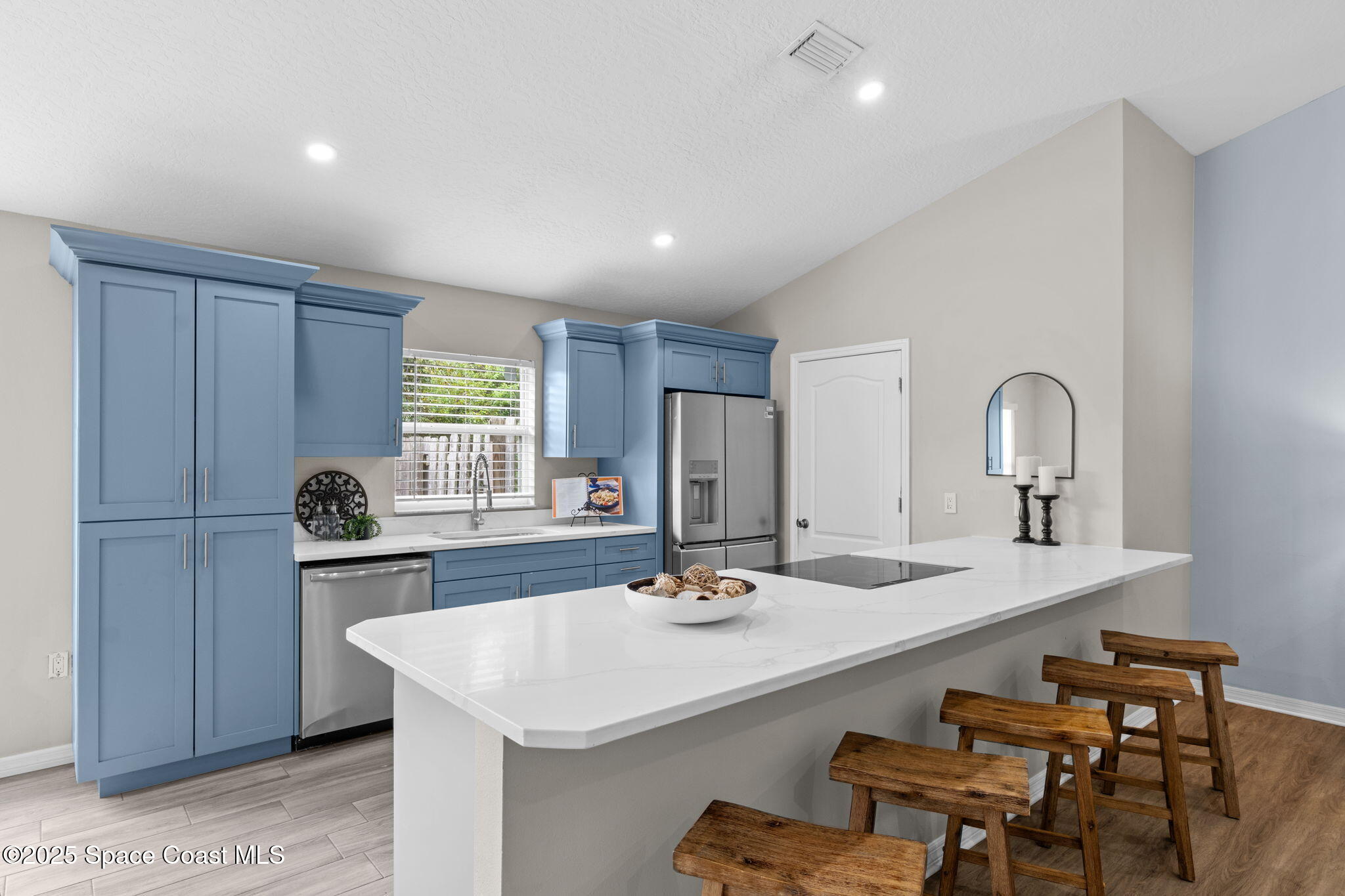 4664 Grand Meadows Boulevard Melbourne, FL 32934 - Photo 10 of 32 a kitchen with stainless steel appliances kitchen island granite countertop a sink and cabinets