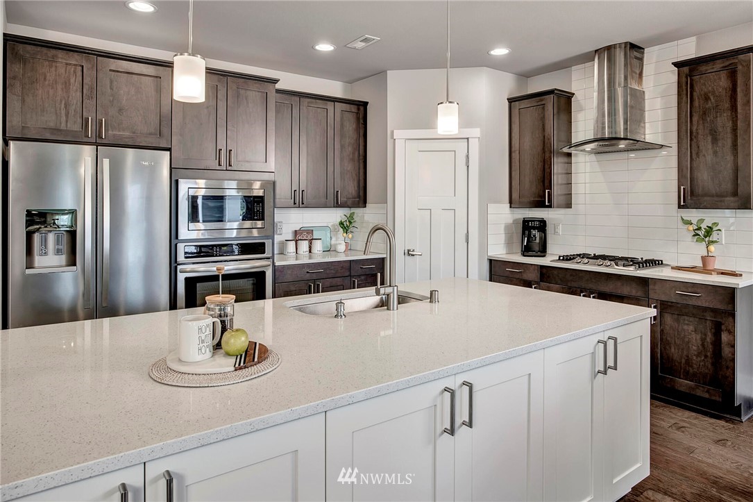 20403 South Danvers Road, Unit B Lynnwood, WA 98036 - Photo 8 of 29 a kitchen with stainless steel appliances kitchen island granite countertop a refrigerator a sink a stove and a refrigerator with wooden floor