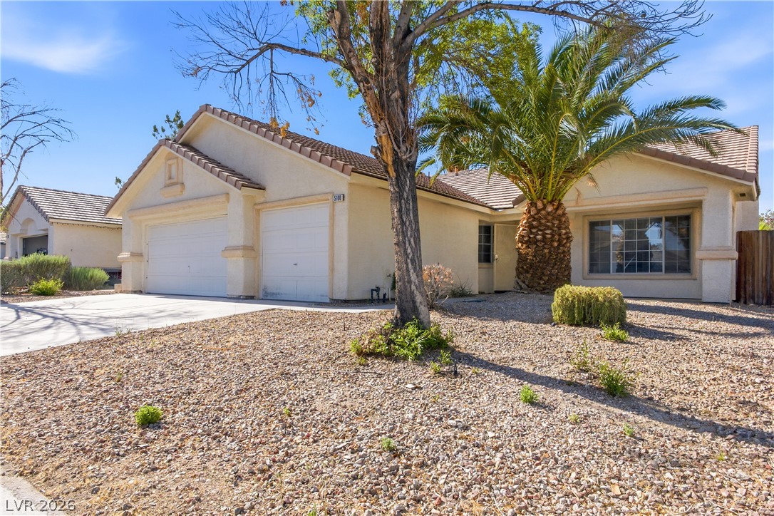 5100 Rancher Avenue Las Vegas, NV 89108 - Photo 2 of 26 A well-maintained facade with an attached double garage and a low-maintenance gravel yard.