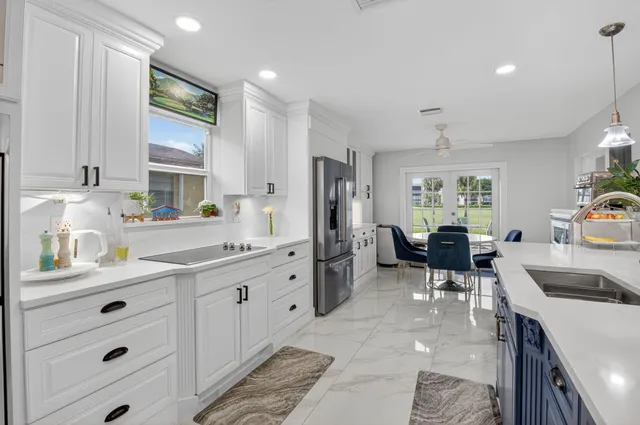 a kitchen that has a lot of cabinets a sink and appliances in it