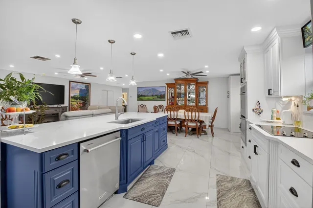a kitchen with kitchen island granite countertop a sink and a refrigerator