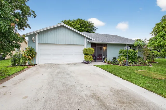 a front view of house with yard and trees all around
