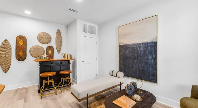 a living room with furniture and wall paintings