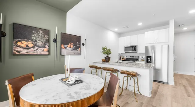 a dining room with furniture and a kitchen view
