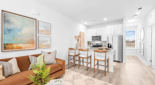 a living room with stainless steel appliances kitchen island granite countertop furniture and a view of kitchen
