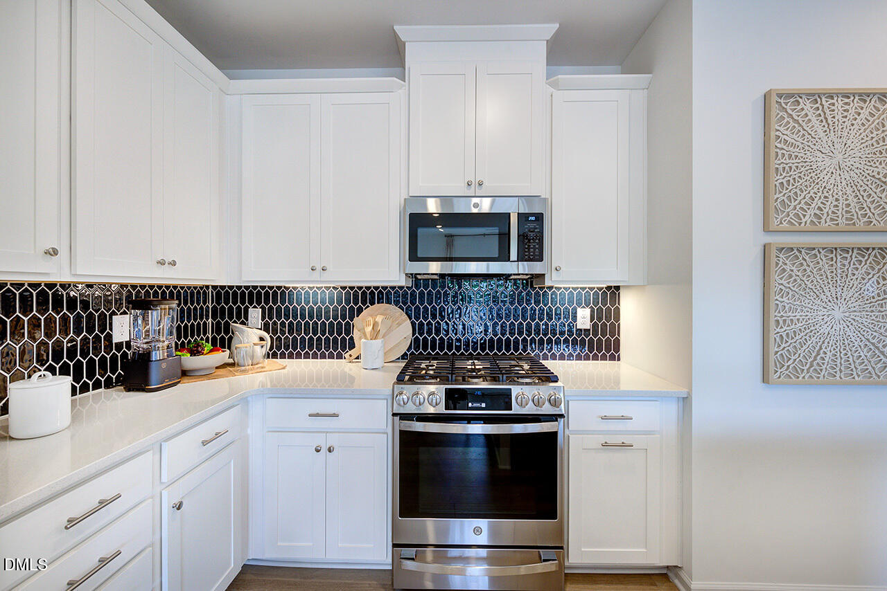 51 Shay Street Angier, NC 27501 - Photo 8 of 41 a kitchen with stainless steel appliances a stove a sink and a microwave