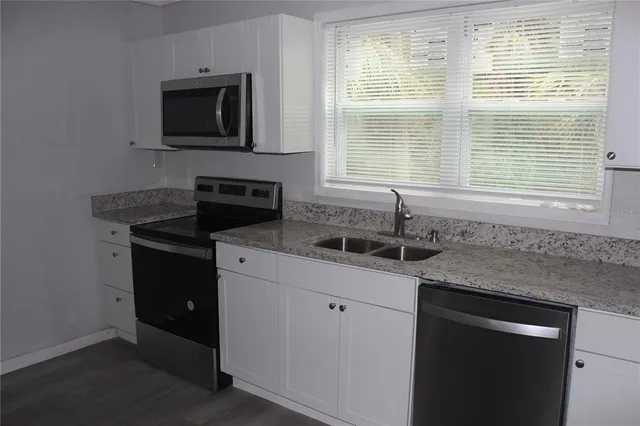a kitchen with a sink stove and microwave