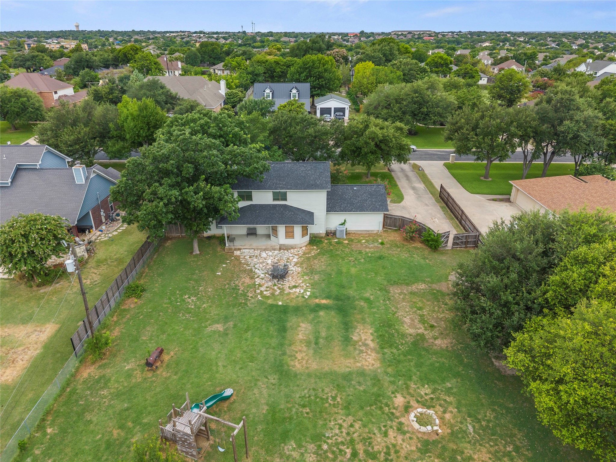 1329 Quail Ravine Round Rock, TX 78664 - Photo 20 of 39 An expansive grassy backyard features mature trees and an overhead view of the neighborhood.