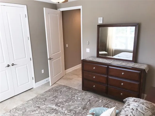 a room with a bed and a mirror on dresser