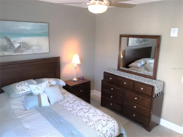 a bedroom with a bed and a mirror on dresser