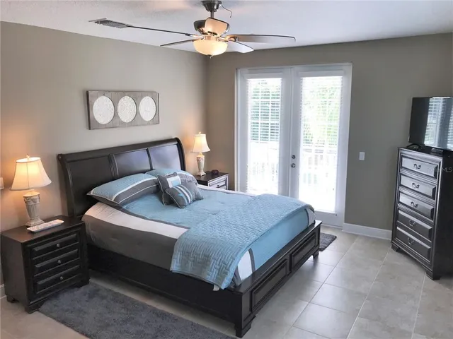 a bed sitting in a bedroom next to a window and a chandelier