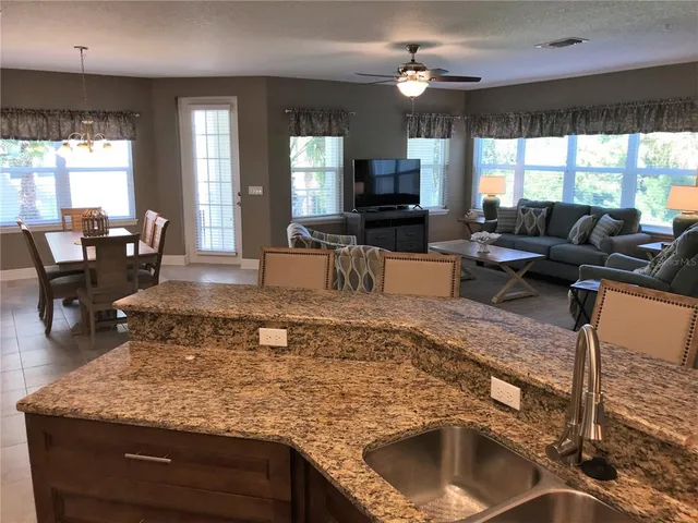 a living room with furniture large window and flat screen tv