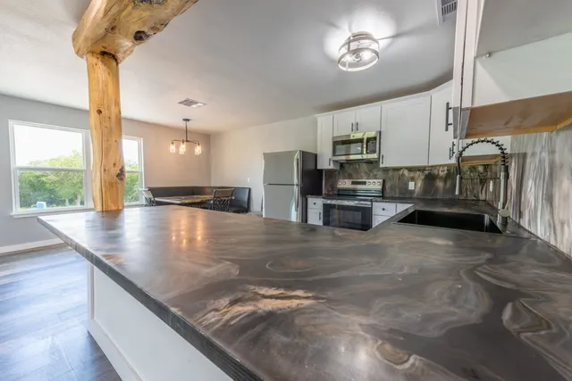 a view of a kitchen with kitchen island a counter space a sink and appliances