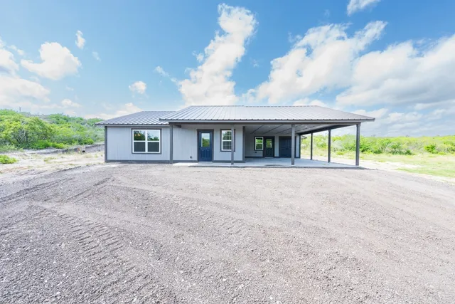a view of an house with backyard and a garden