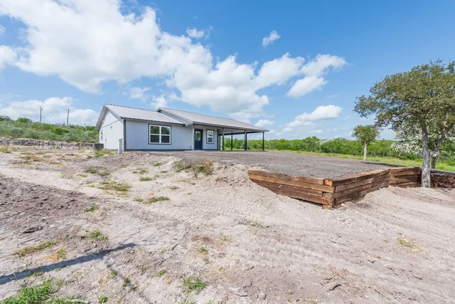 a view of a dry yard with wooden fence