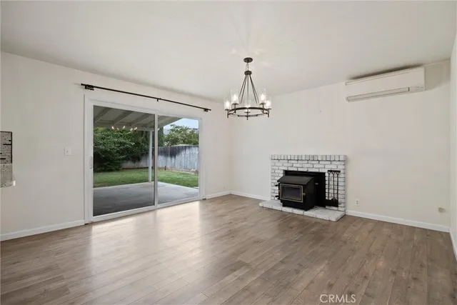 an empty room with fireplace wooden floor and windows
