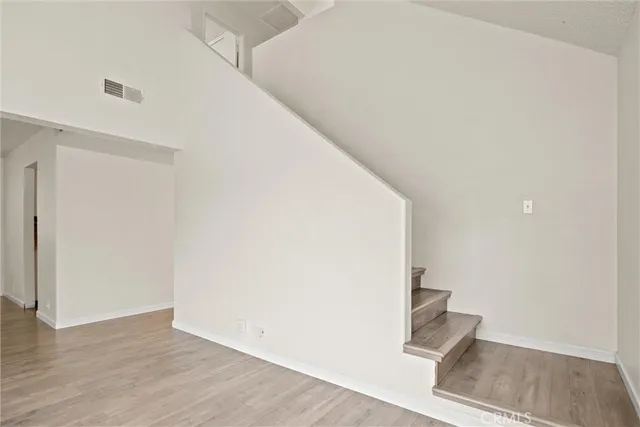 a view of a hallway with wooden floor and entryway