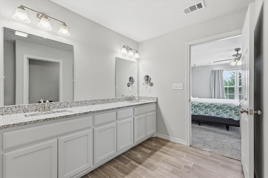 110 Highview Road Ennis, TX 75119 - Photo 19 of 40 Dual vanity with white cabinetry, granite-finish countertops, and chrome fixtures