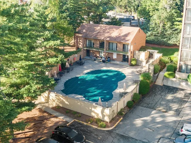 a view of a patio with table and chairs potted plants and large tree