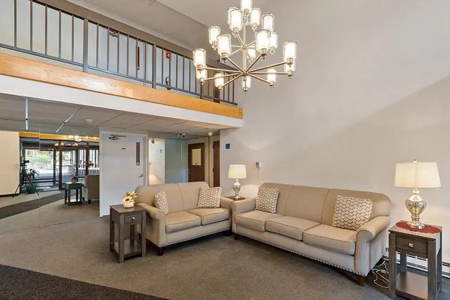 a living room with furniture a chandelier and a dining table