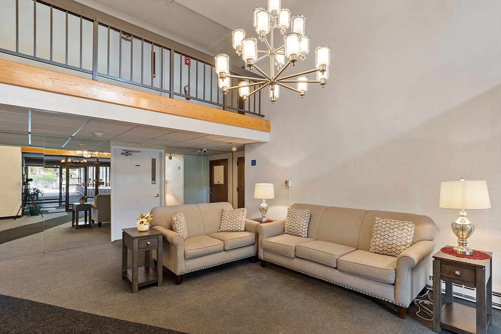 190 High Street, Unit 605 Medford, MA 02155 - Photo 35 of 37 a living room with furniture a chandelier and a dining table