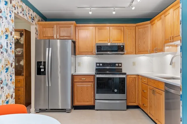a kitchen with stainless steel appliances granite countertop a refrigerator and a sink