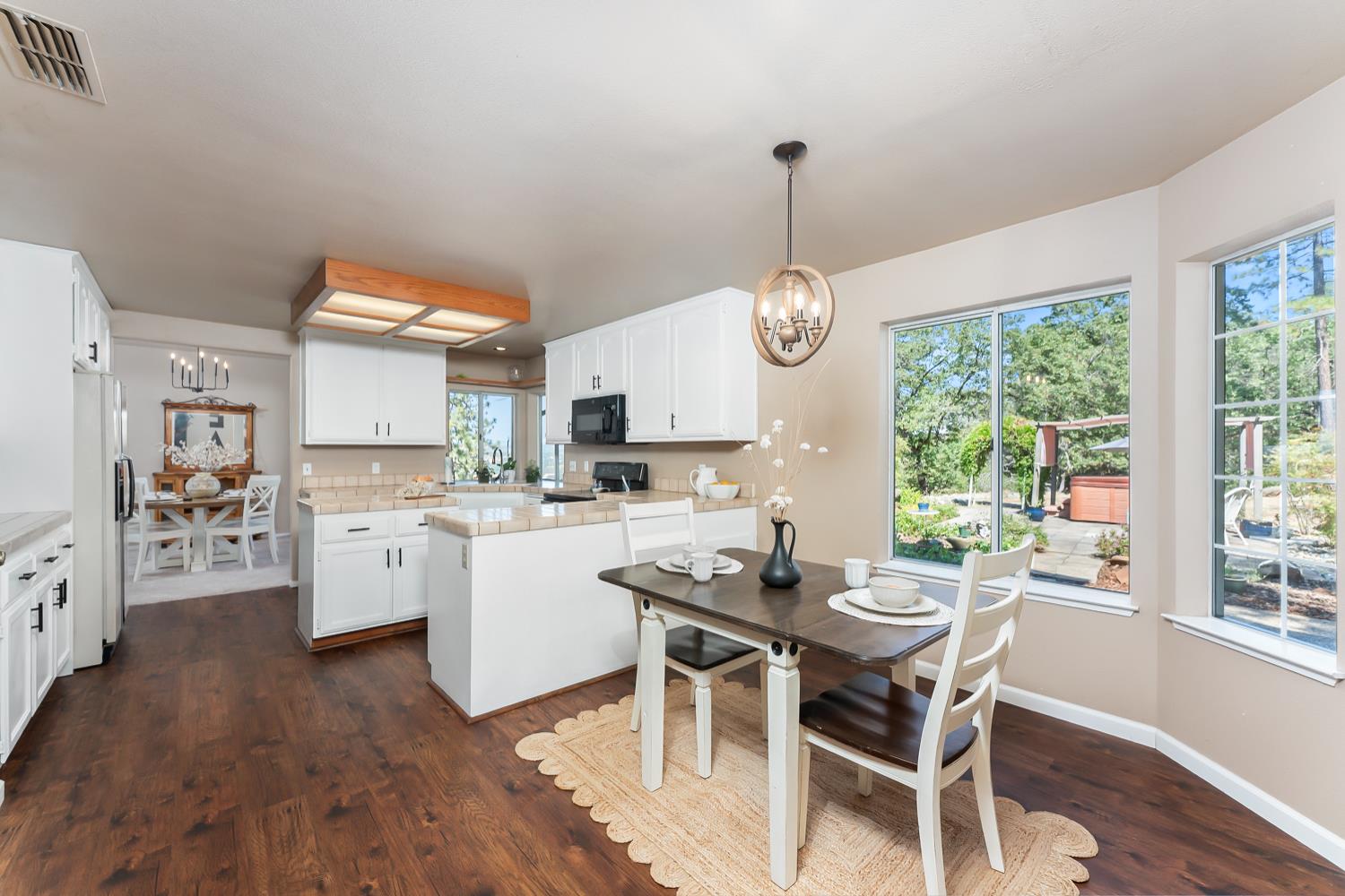 3472 See View Court Rescue, CA 95672 - Photo 19 of 56 a dining room with wooden floor a chandelier a wooden table and chairs