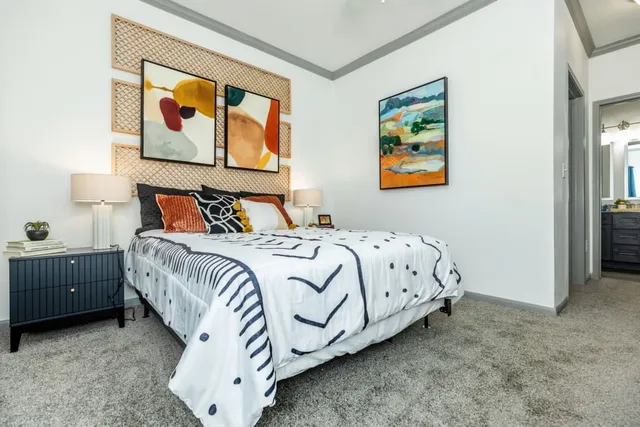 a bedroom with a bed and painting on the wall