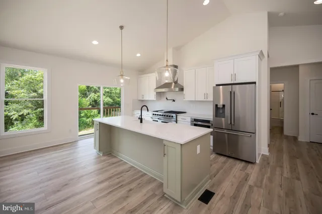 a large kitchen with stainless steel appliances kitchen island a large counter top and stove top oven