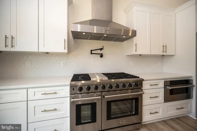 a large kitchen with a sink and a refrigerator