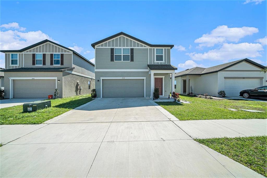 35542 Buttonweed Trail Zephyrhills, FL 33541 - Photo 1 of 30 a front view of a house with a yard and garage