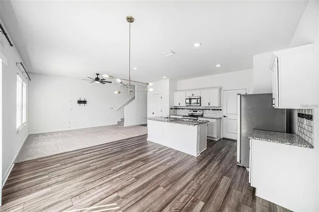 a large kitchen with kitchen island a sink stainless steel appliances and cabinets
