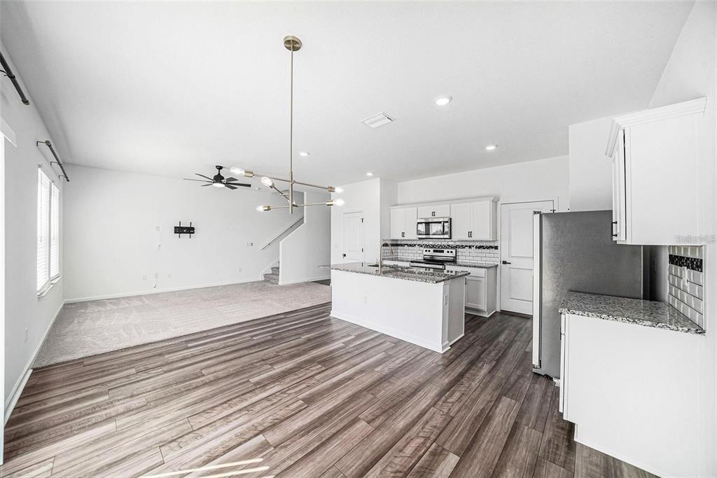 35542 Buttonweed Trail Zephyrhills, FL 33541 - Photo 11 of 30 a large kitchen with kitchen island a sink stainless steel appliances and cabinets