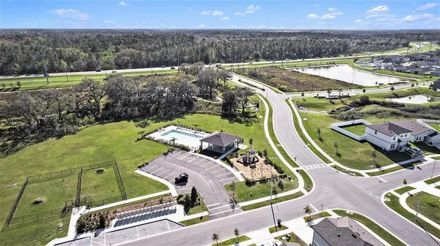 an aerial view of a house with a garden and lake view