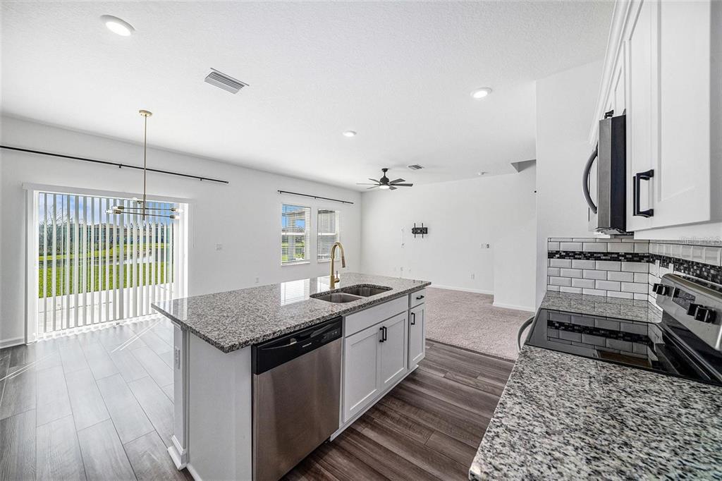 35542 Buttonweed Trail Zephyrhills, FL 33541 - Photo 4 of 30 a kitchen with a stove and a wooden floor