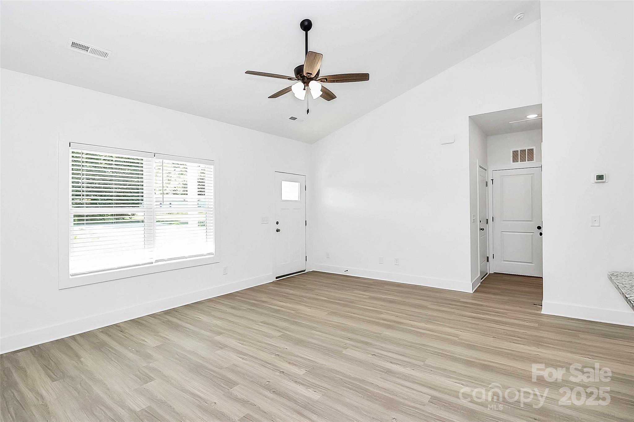 6122 Lowder Road Salisbury, NC 28147 - Photo 5 of 31 an empty room with wooden floor chandelier fan and windows