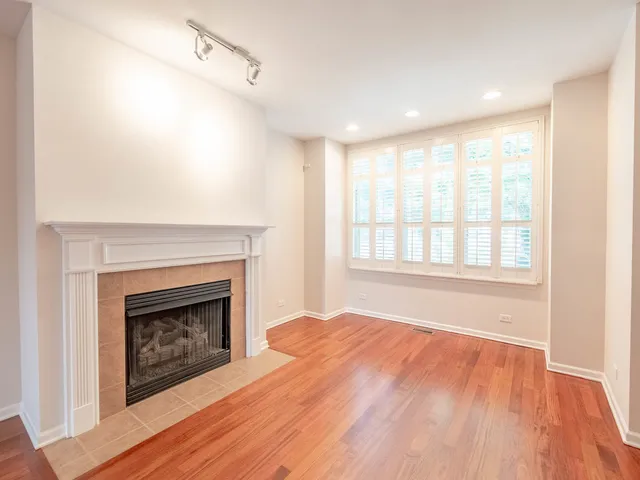a view of empty room with wooden floor and fireplace
