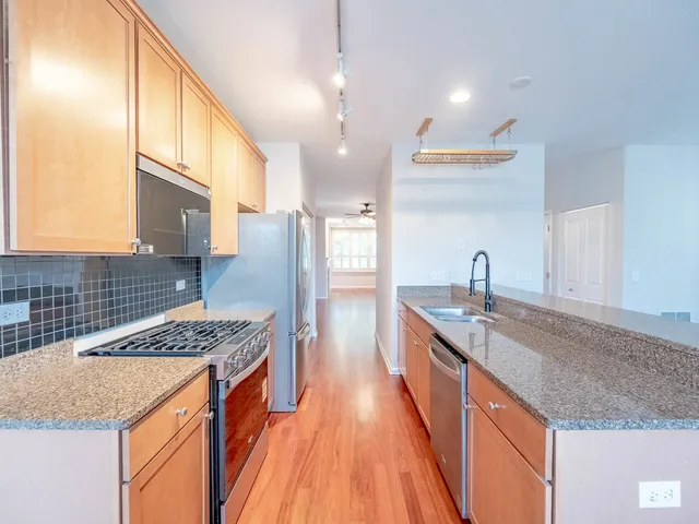 a kitchen with stainless steel appliances granite countertop a sink stove and refrigerator