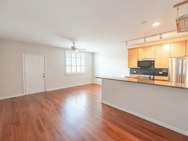 a view of a kitchen with wooden floor and a window
