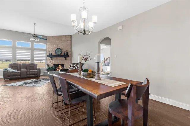 a view of a dining room with furniture a chandelier and wooden floor