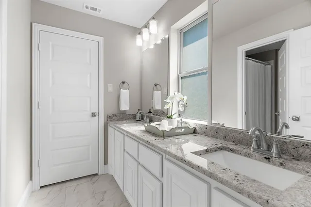 a bathroom with a granite countertop sink toilet and shower